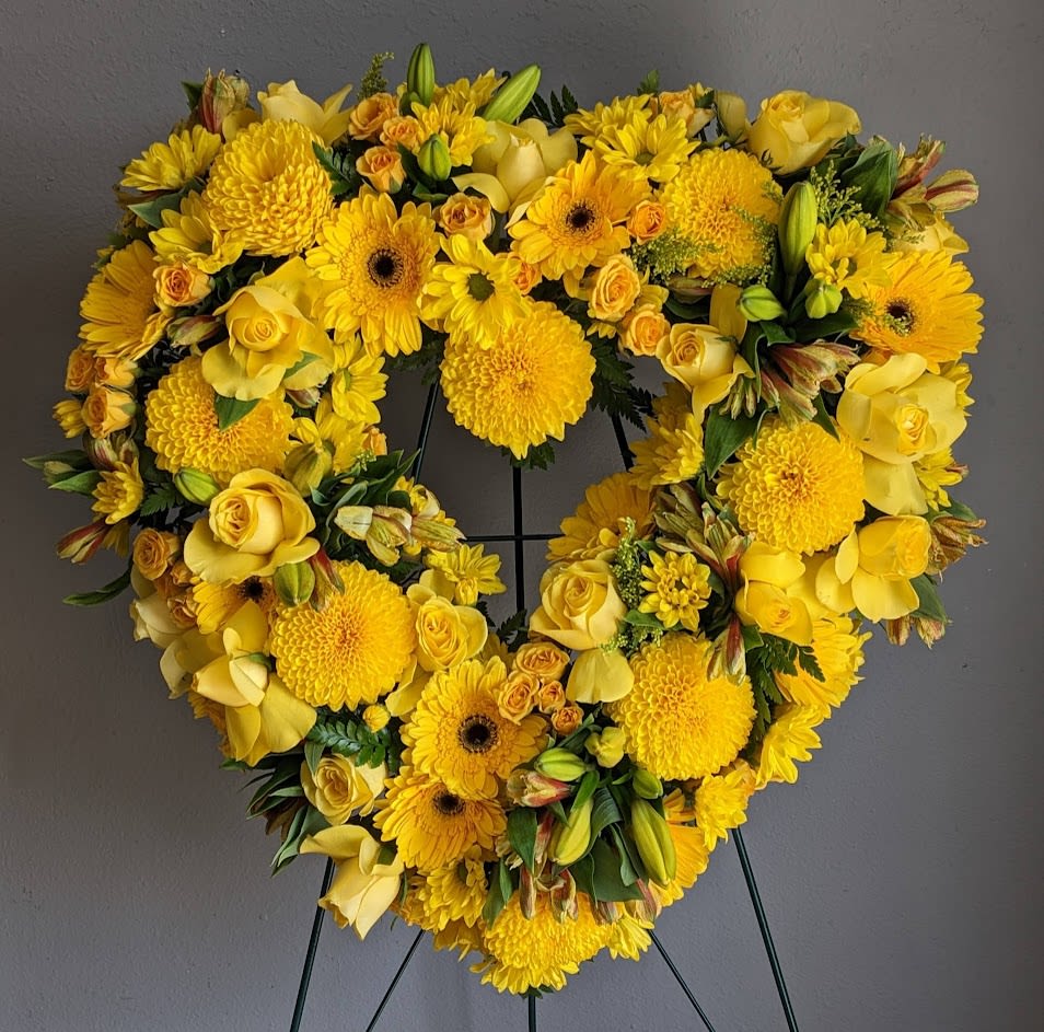 FUNERAL HEART WREATH - I Carry Your Heart 75 - This is a bright option for a funeral service, church or graveside. This open heart arrangement will be designed with an 18", 24”, or 30" heart form and will be delivered on a stand. This lovely mix of yellow roses, daisies and lilies is the perfect way to add some brightness and color to a day of remembrance.   **This is a piece for a funeral or memorial service. Please place the order at least 2 days prior to the service to guarantee a certain arrangement. Anything sooner and we cannot guarantee it will match the picture. These pieces can be customized to the color of your choice. The flowers may vary depending on availability of the flowers, special requests and quality of the flowers we have in stock. If you have a special request please add it to our special instructions when placing your order. If you have any questions please don’t hesitate to call. 714 289 1123**
