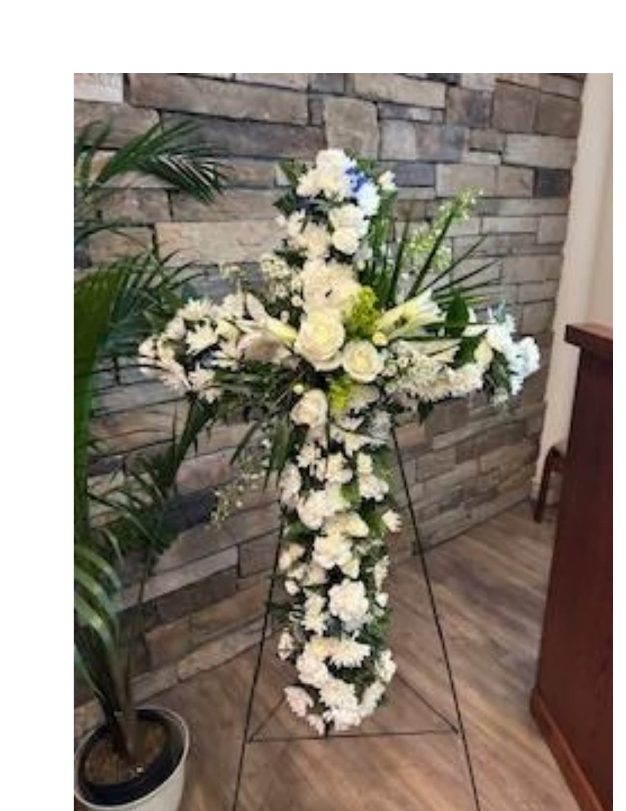 White floral standing cross on an easel