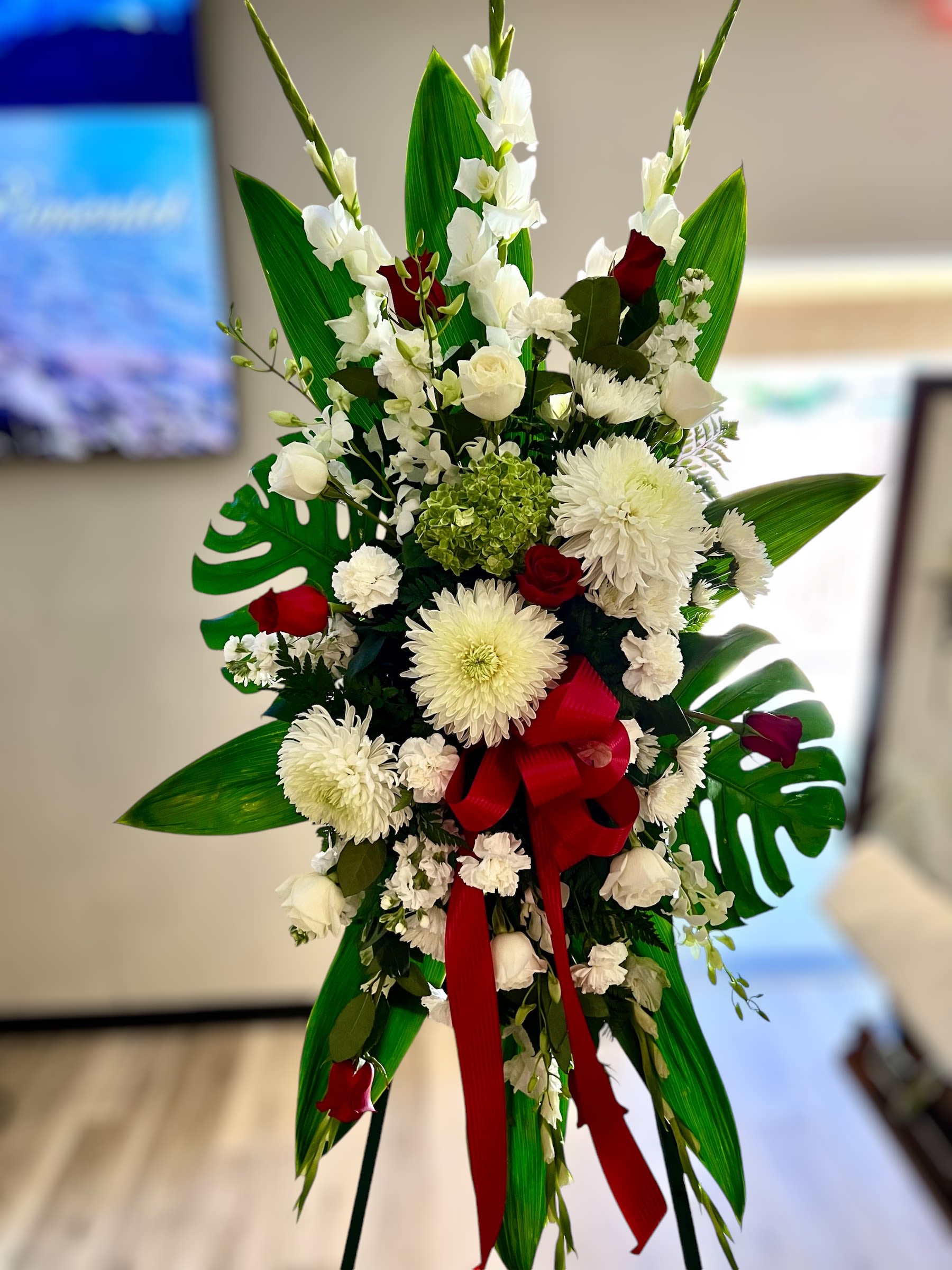 Tall white and red standing spray with large mums and roses on an easel