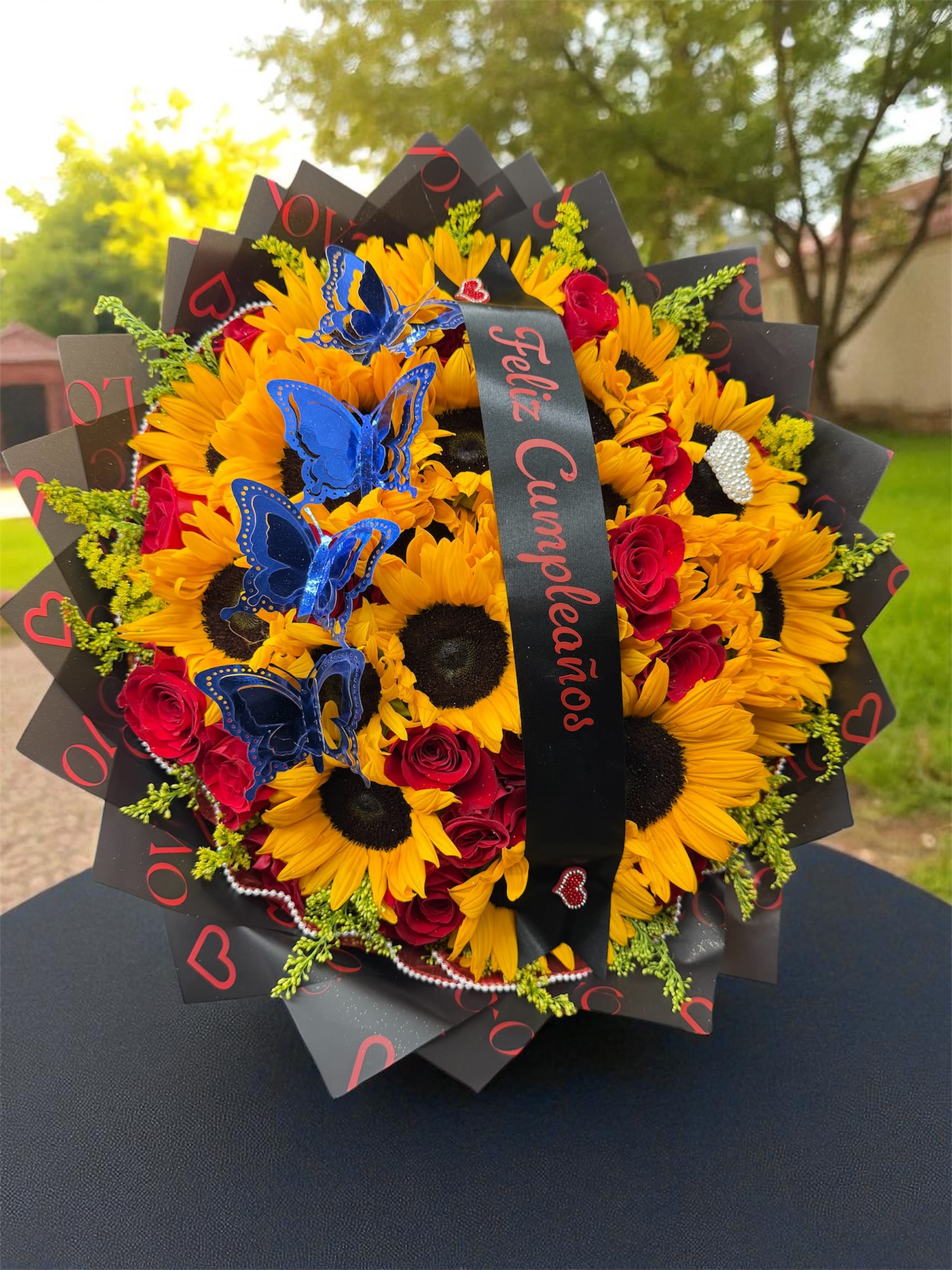 Bouquet of sunflowers and red roses with blue butterfly picks