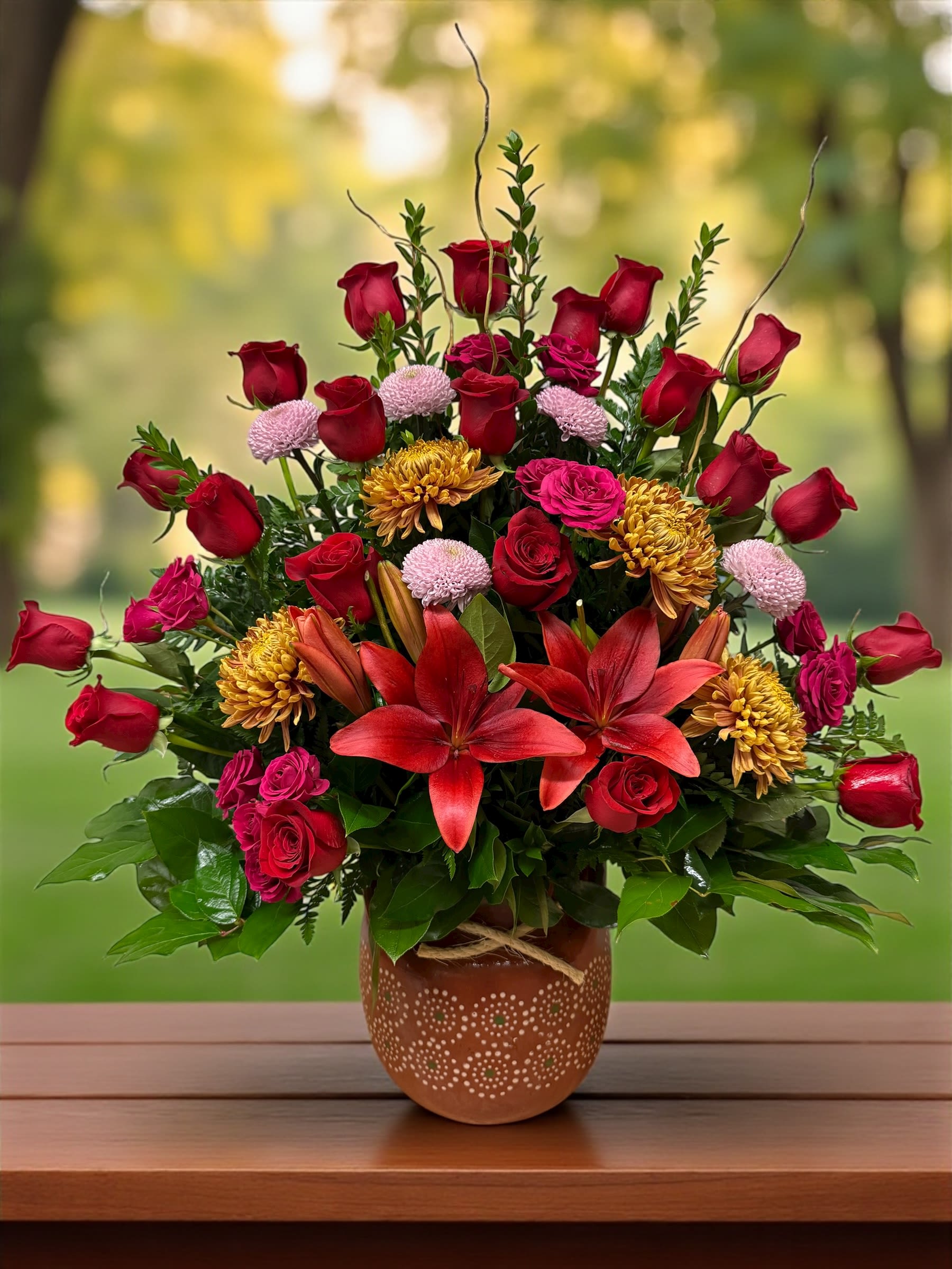 Red roses and lilies arranged in a decorative vase