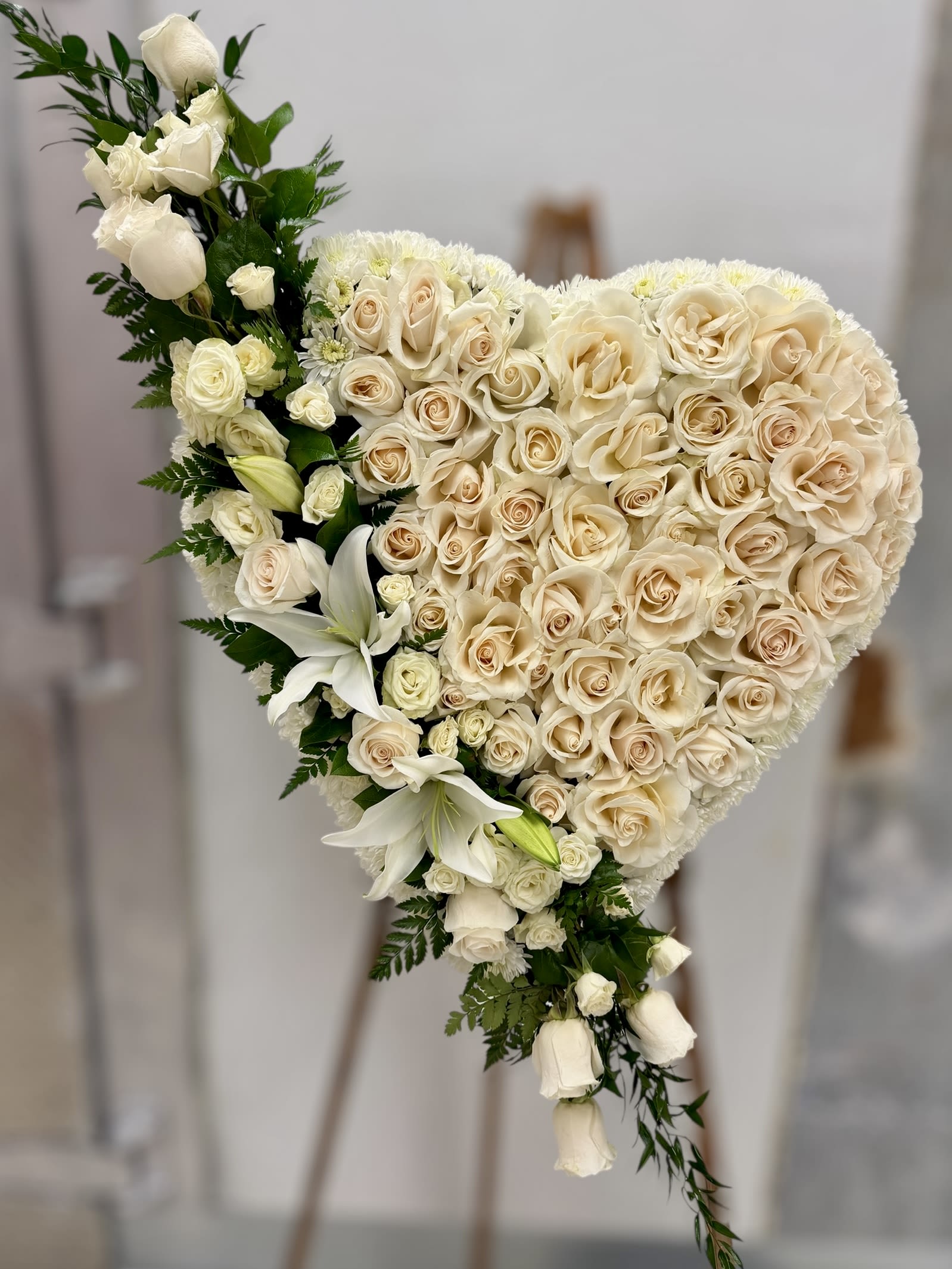 Heart-shaped bouquet of cream roses and white lilies