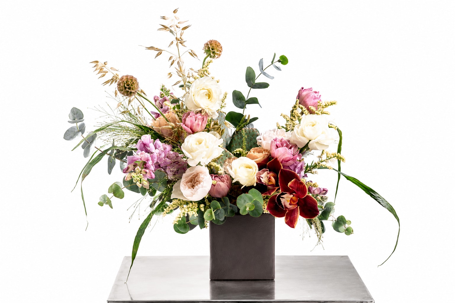 Mixed floral arrangement in a dark square vase with pink, white, and burgundy blooms