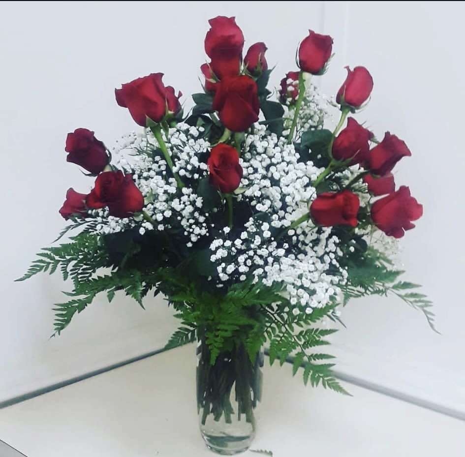 Bouquet of red roses and white baby's breath in a clear glass vase