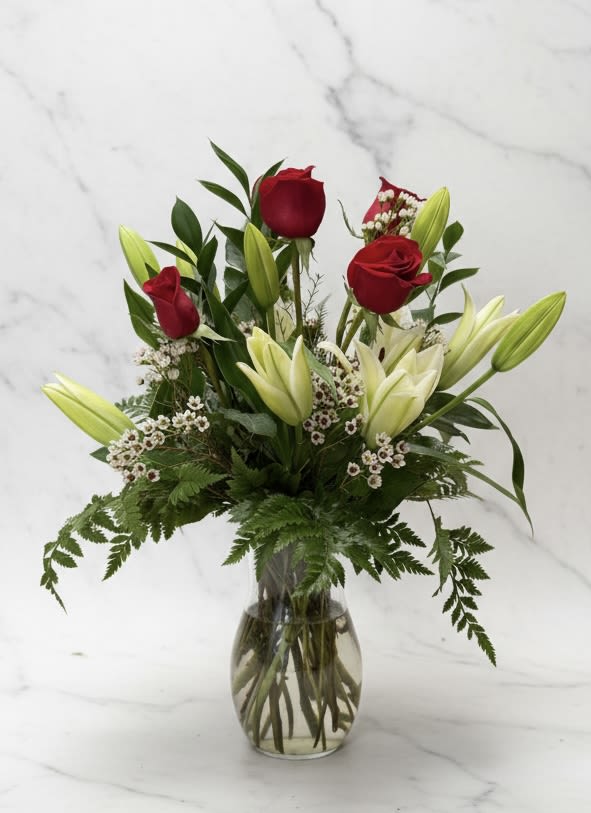 Red roses and white lilies in a clear glass vase