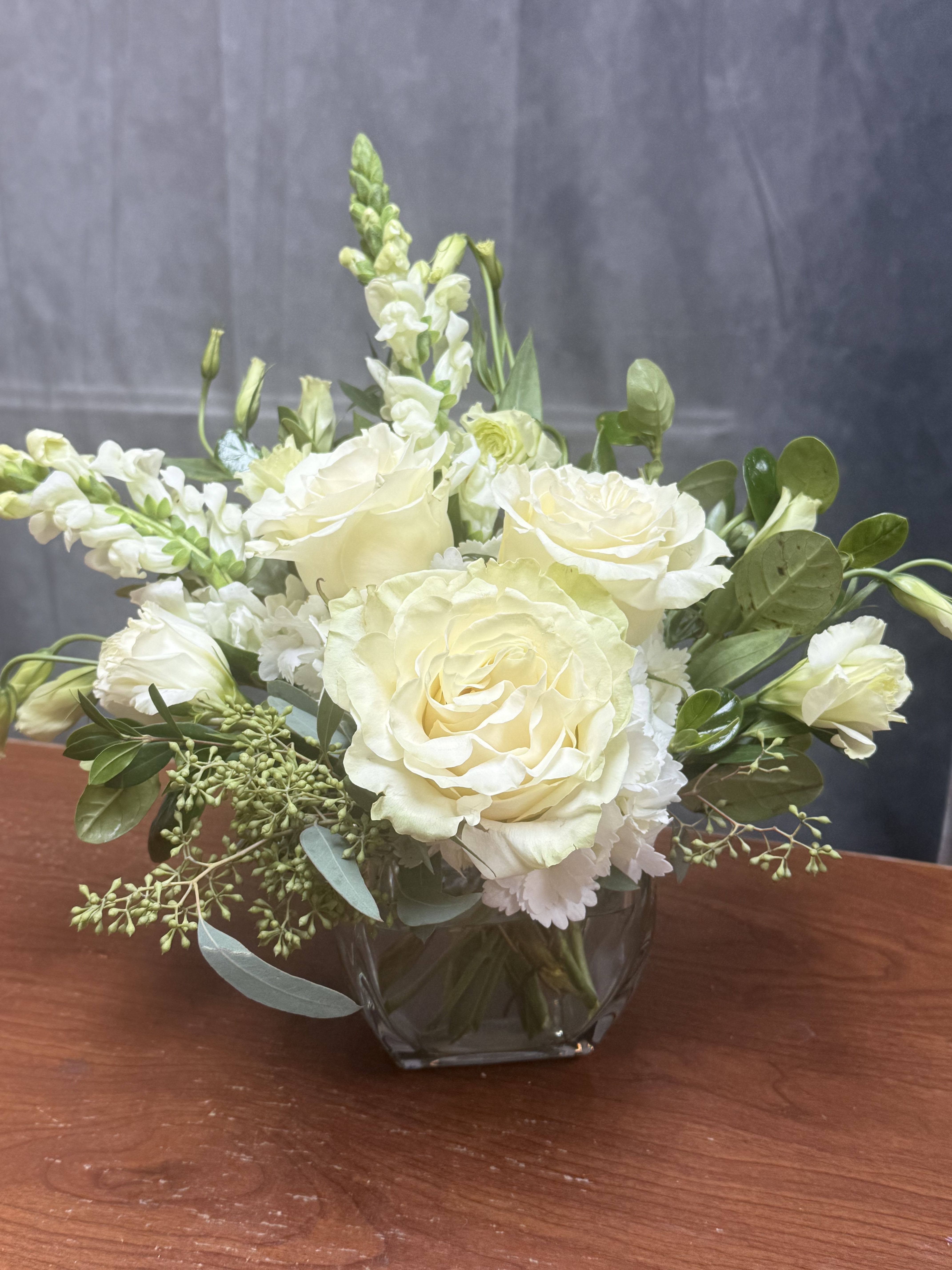 Cream rose bouquet in a clear glass vase