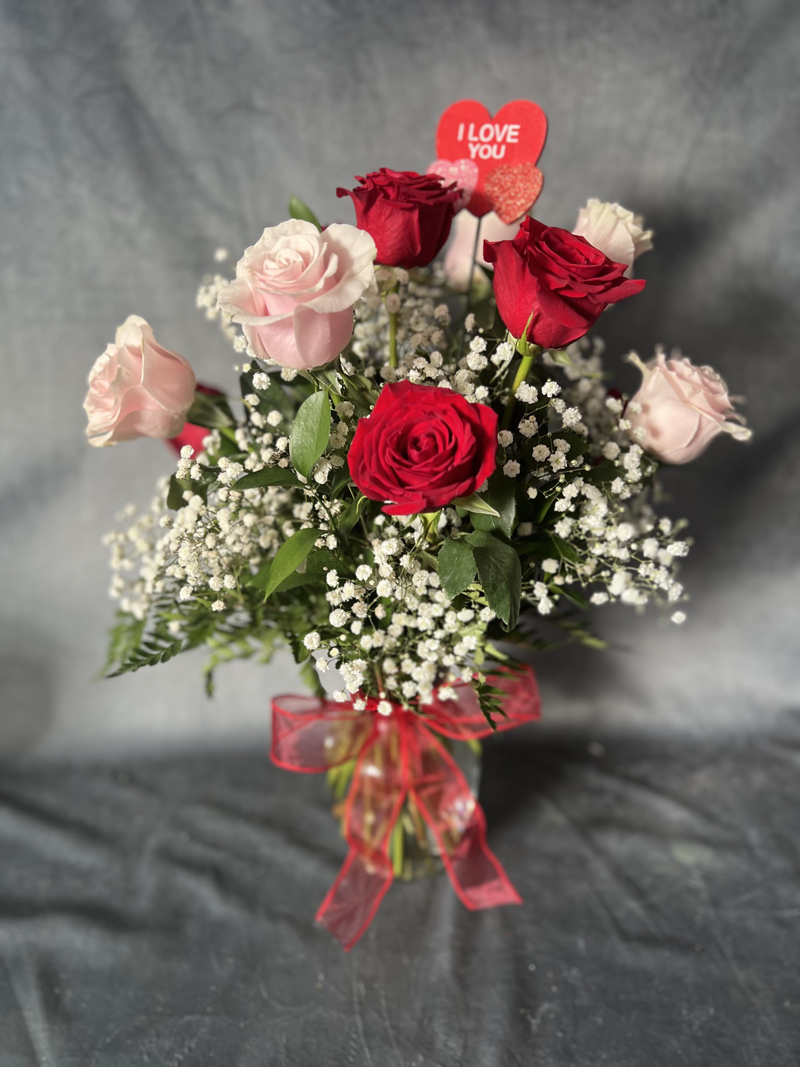 Bouquet of red and pale pink roses with a heart topper and red ribbon