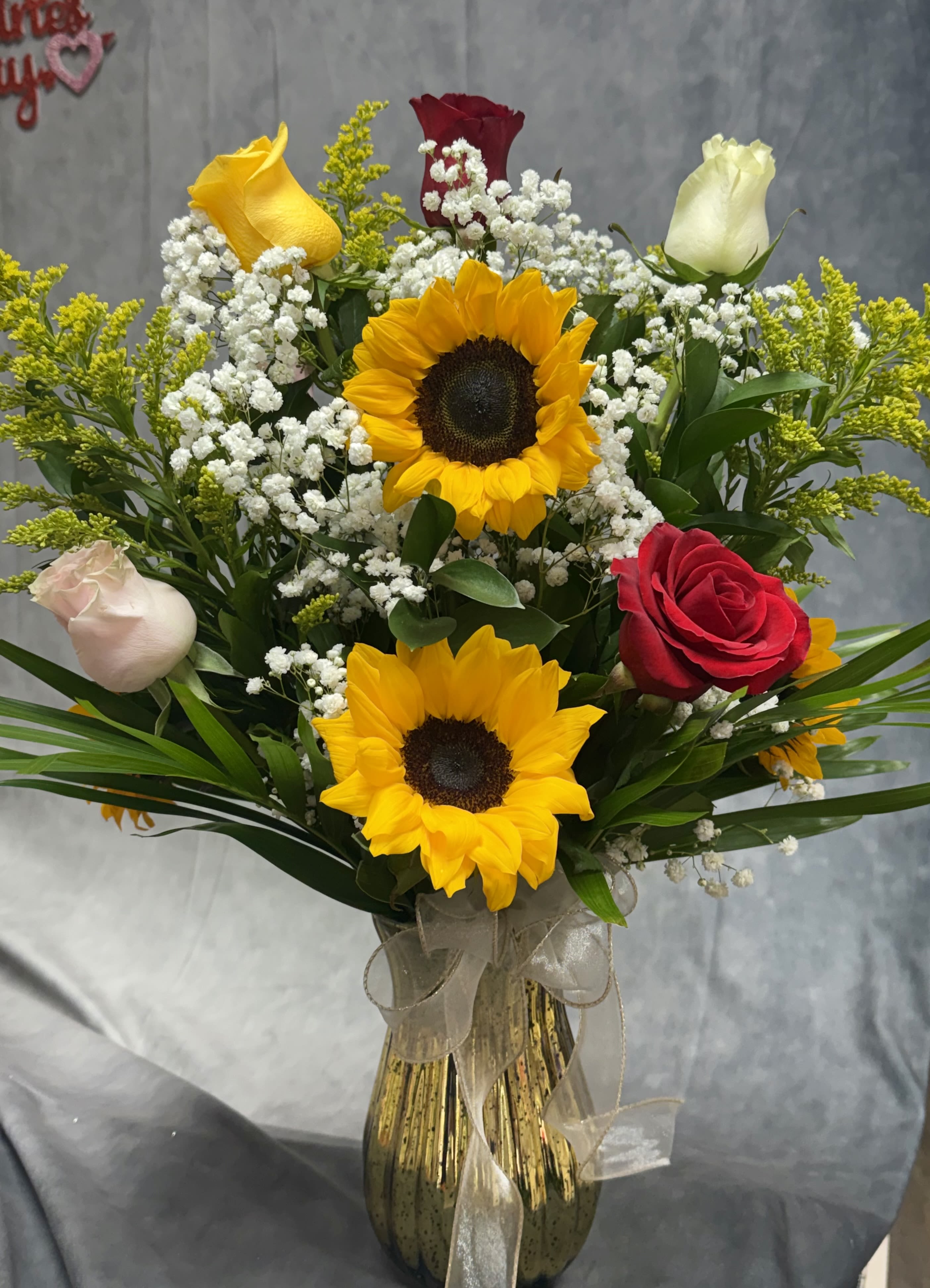Bouquet of sunflowers and roses in a glass vase