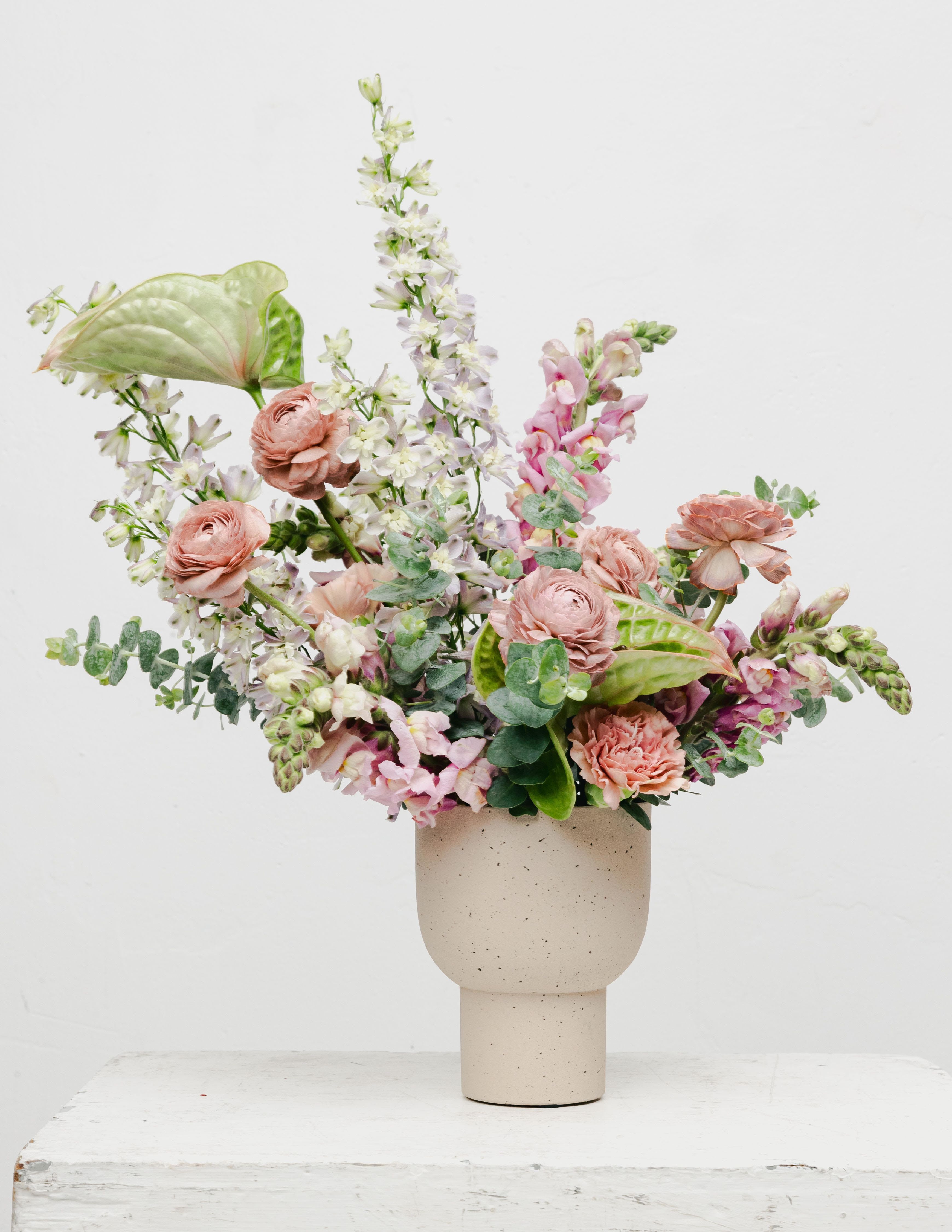 Mauve  - Discover the elegance of our Artful Mauve and Green Flower Arrangement, an exquisite design that beautifully combines soft mauve blooms with rich greenery, creating a harmonious and sophisticated display. This arrangement showcases an artistic shape that draws the eye and adds a touch of creativity to any space. The Artful Mauve and Green Flower Arrangement is a perfect expression of sophistication and creativity, merging colors and shapes that embody the beauty of nature. Experience the enchanting charm of this floral masterpiece that effortlessly adds style and elegance to any setting!