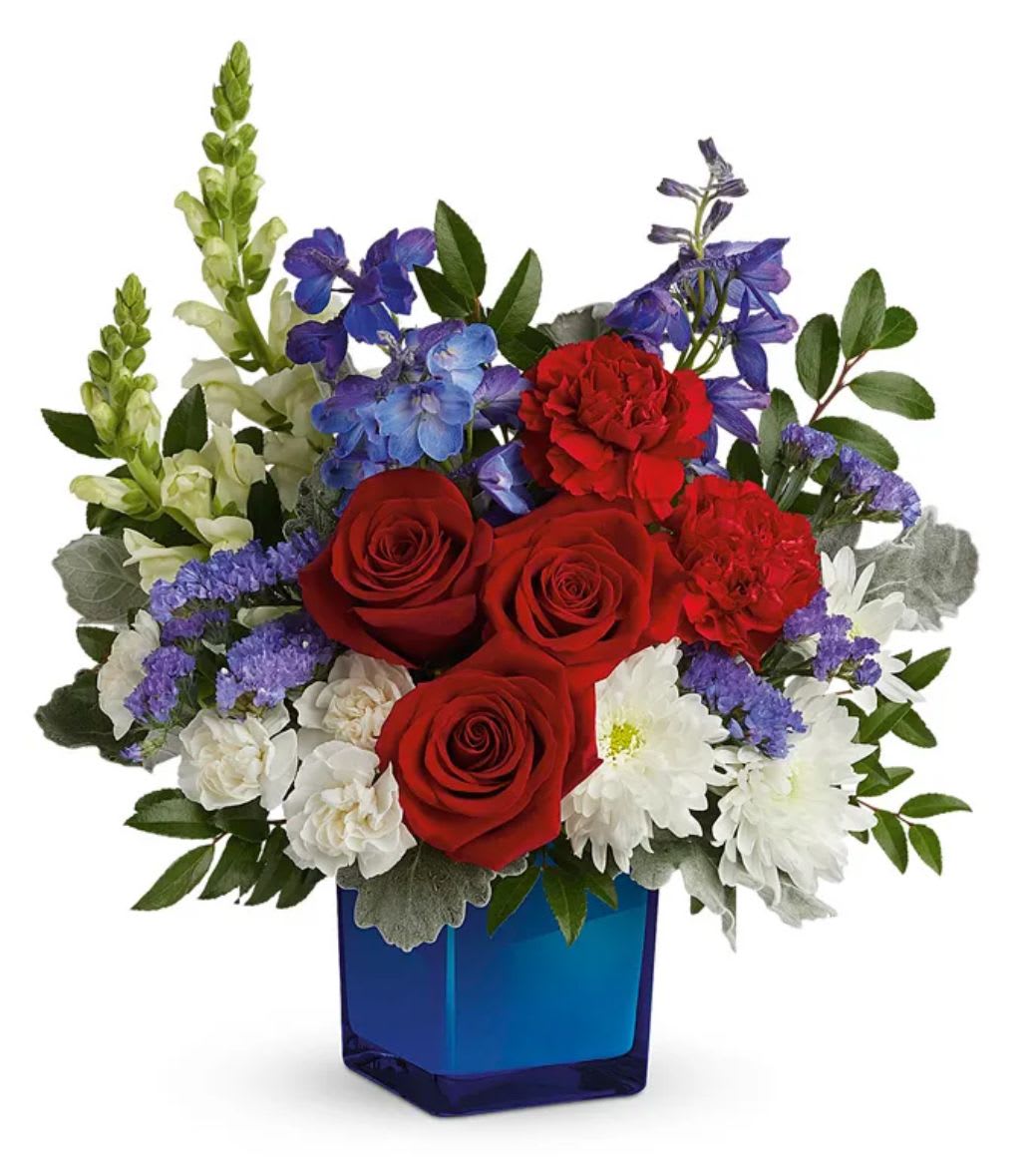 Red roses, white daisies, and purple flowers in a blue vase