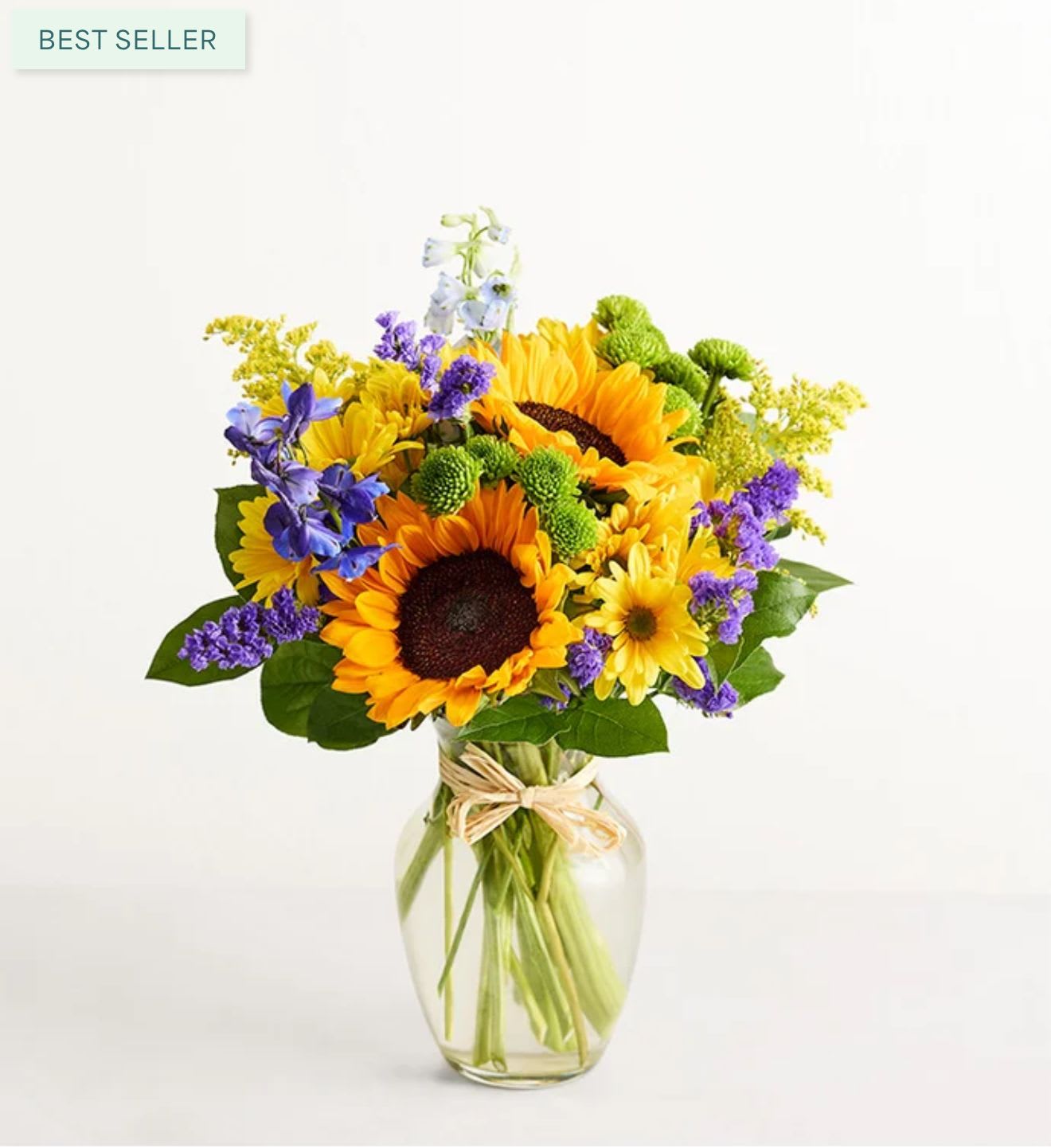 Sunflower bouquet in a clear glass vase with purple and yellow accents