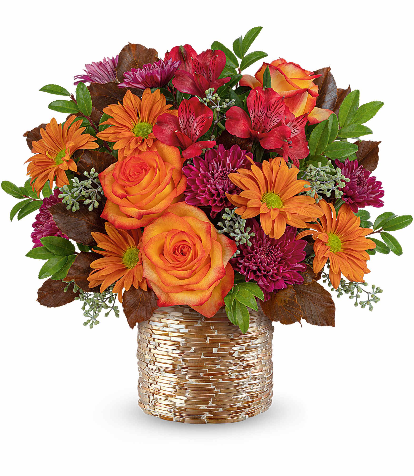 Orange roses and magenta daisies in a gold-textured vase