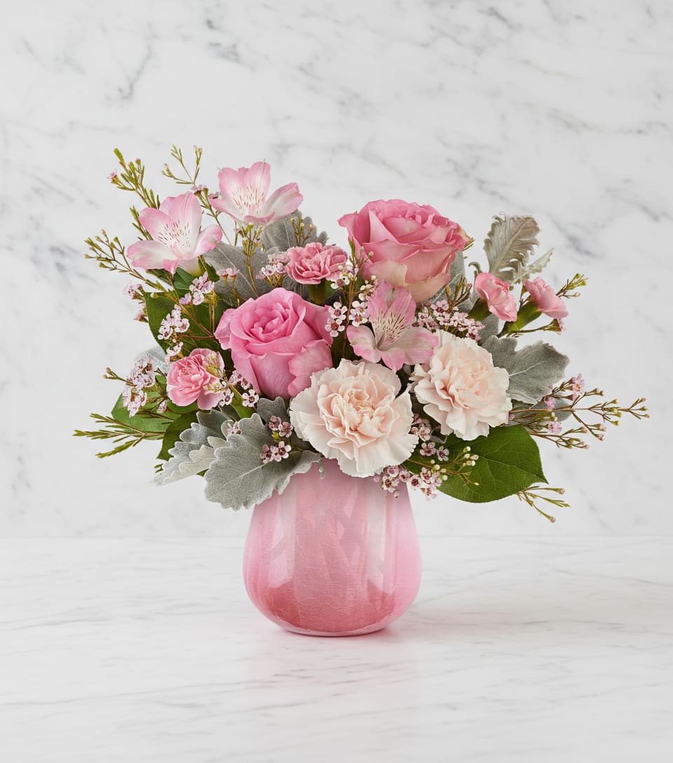 Pink roses and carnations in a pink glass vase