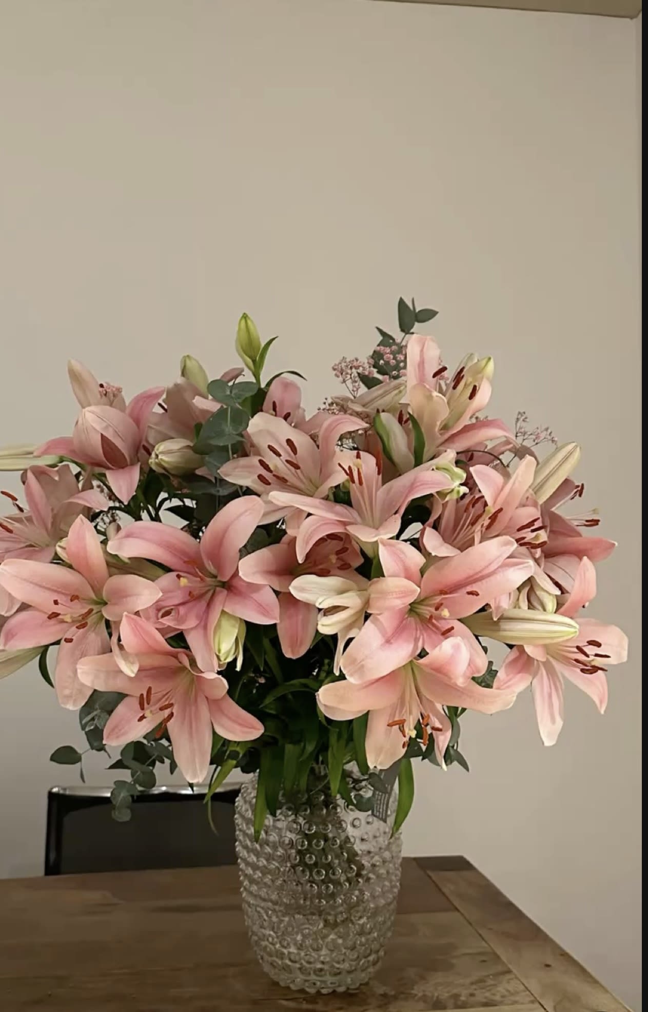 Pink lilies arranged in a clear textured vase