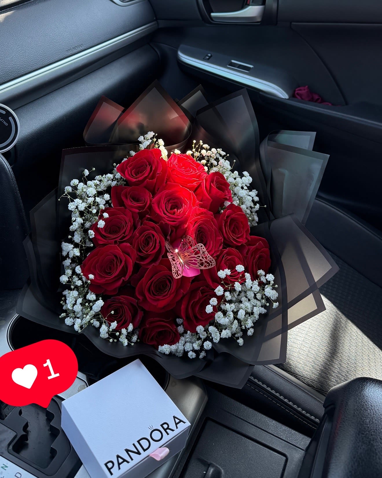 Bouquet of red roses with white baby's breath in black wrap