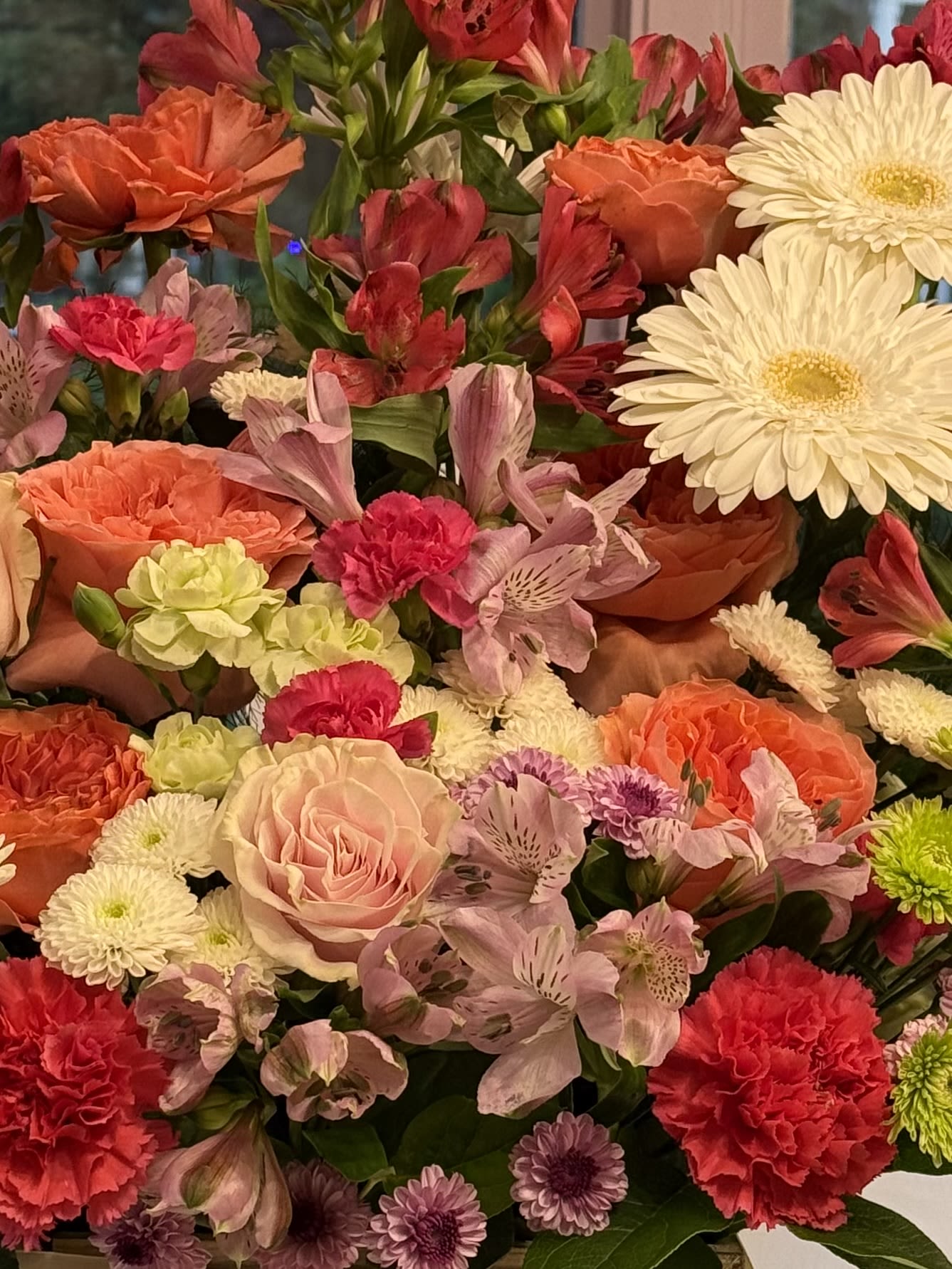 Mixed bouquet with roses, carnations, daisies, and alstroemeria in pink, orange, and white