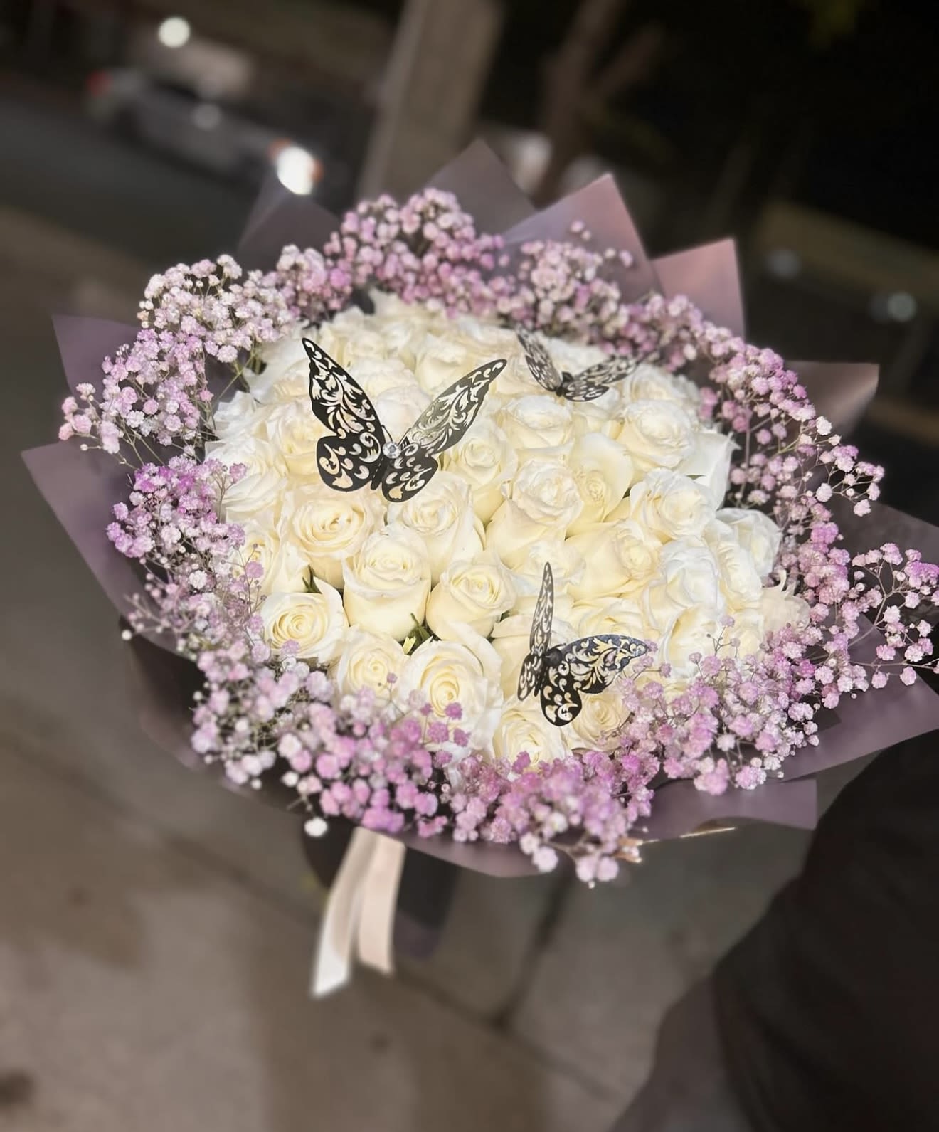 Bouquet of white roses with pink baby's breath and butterfly picks