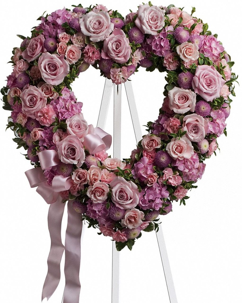 Heart-shaped pink and lavender floral wreath on an easel with ribbon