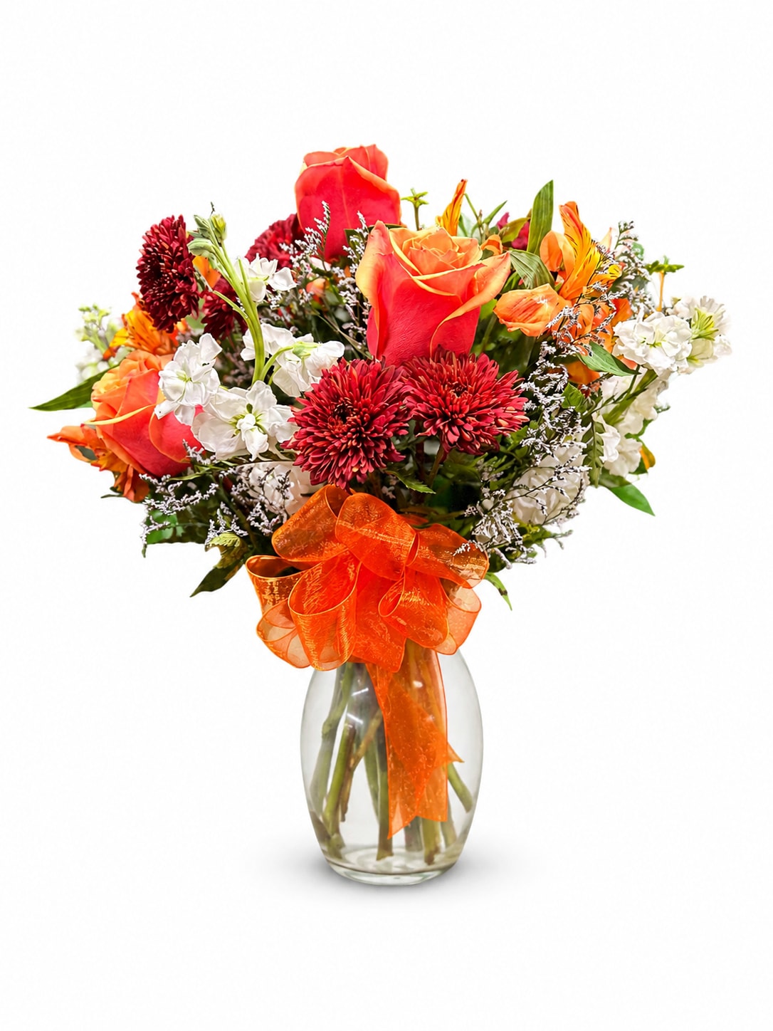 Bouquet of red and orange roses with white flowers in a glass vase