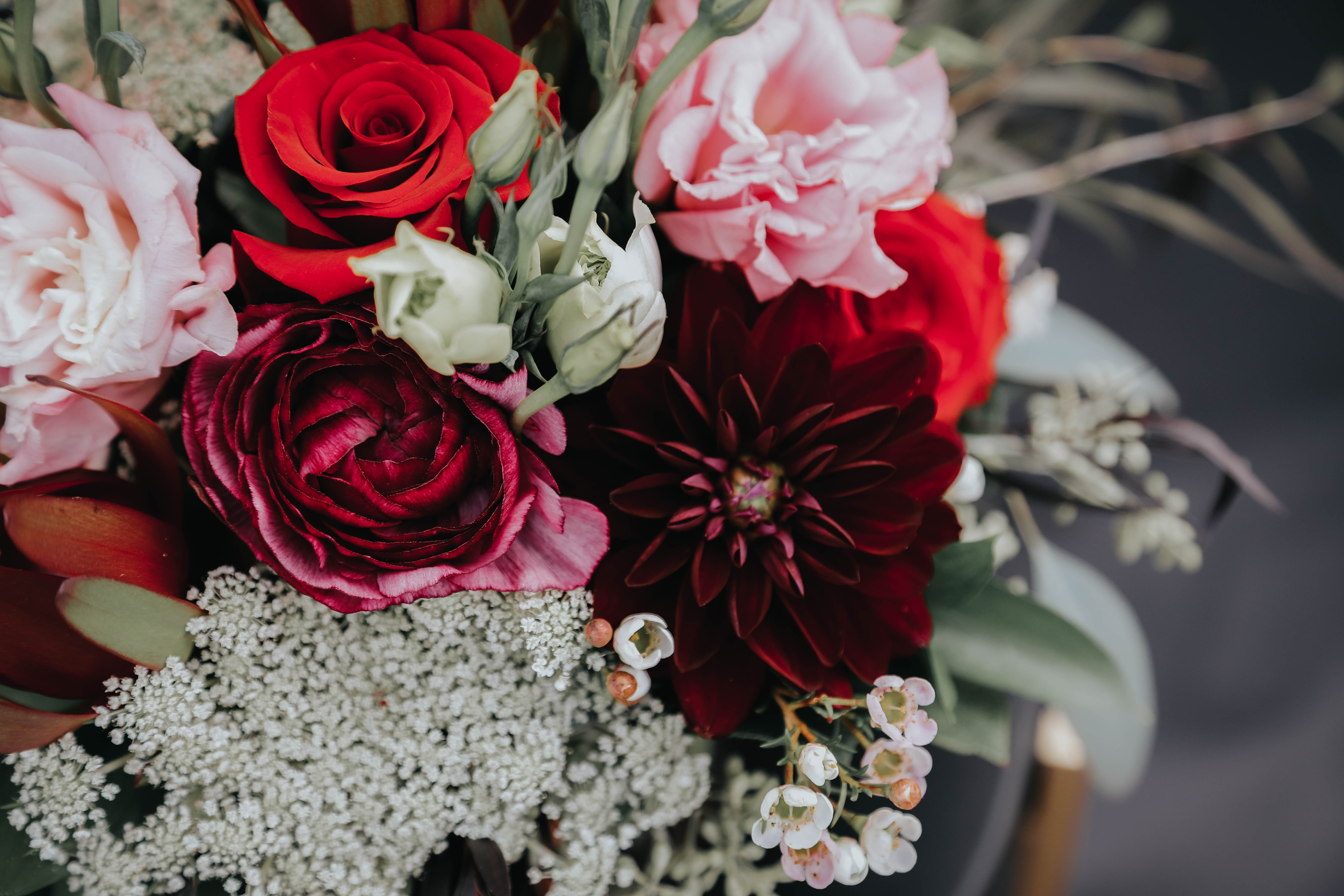 Bouquet of red, pink, and white flowers with dark burgundy blooms