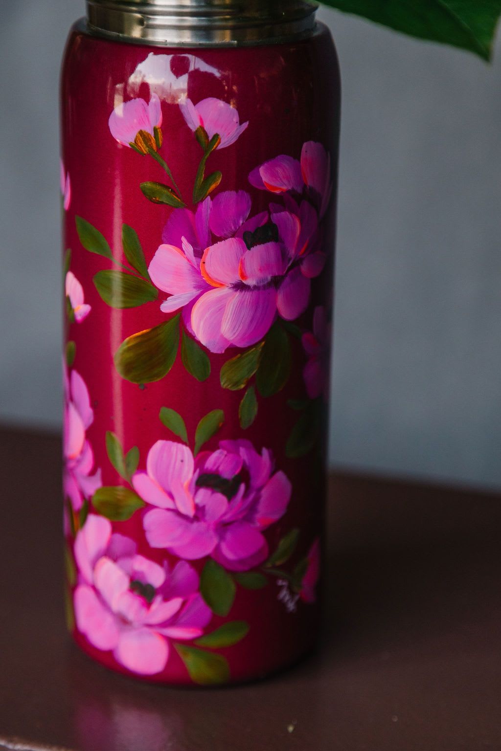 Pink floral-painted tumbler with a metal lid