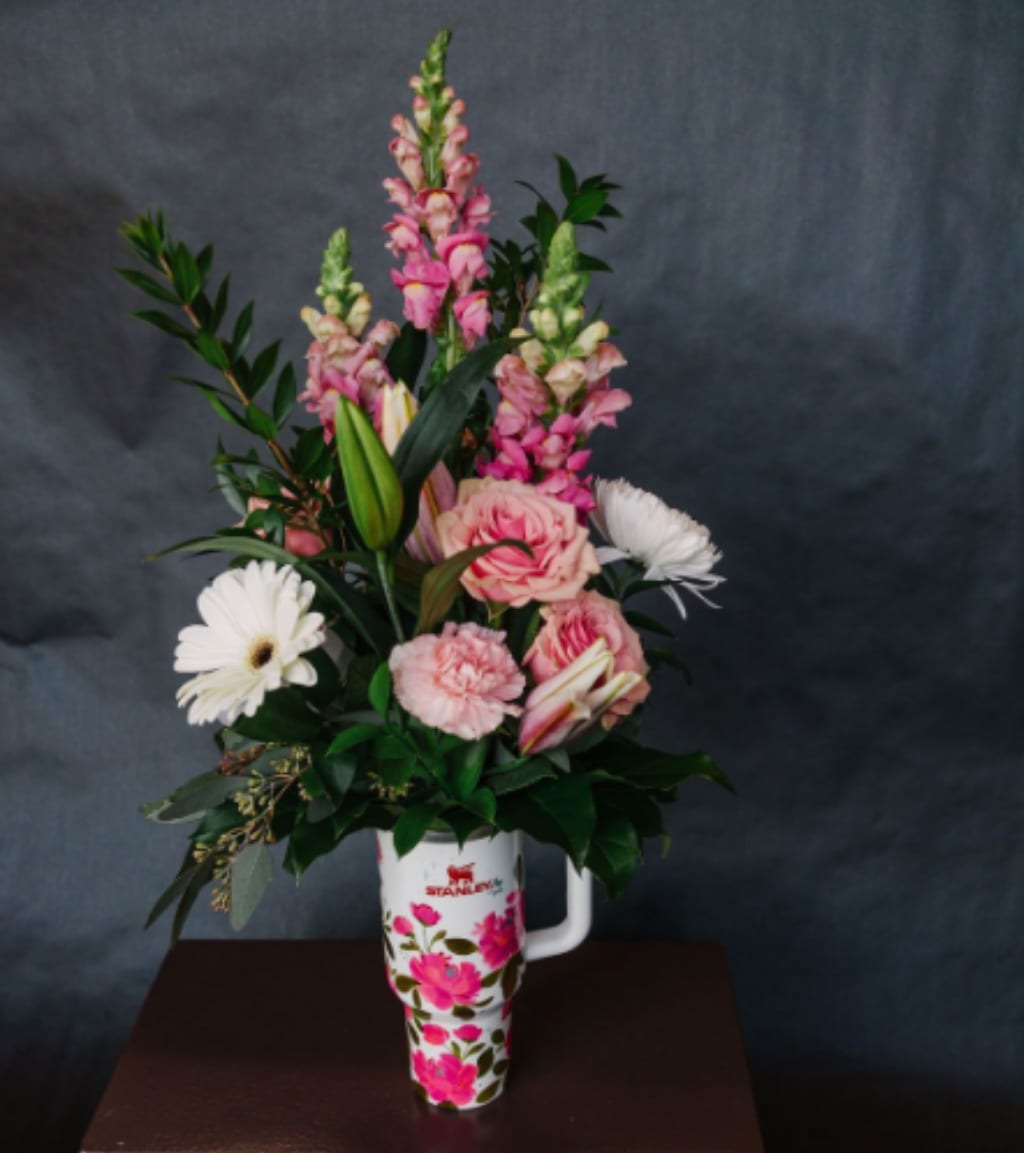 Pink and white flowers arranged in a floral tumbler