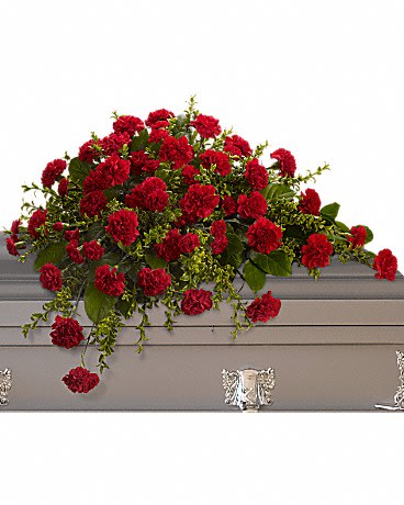 Red carnation spray arranged on a gray casket