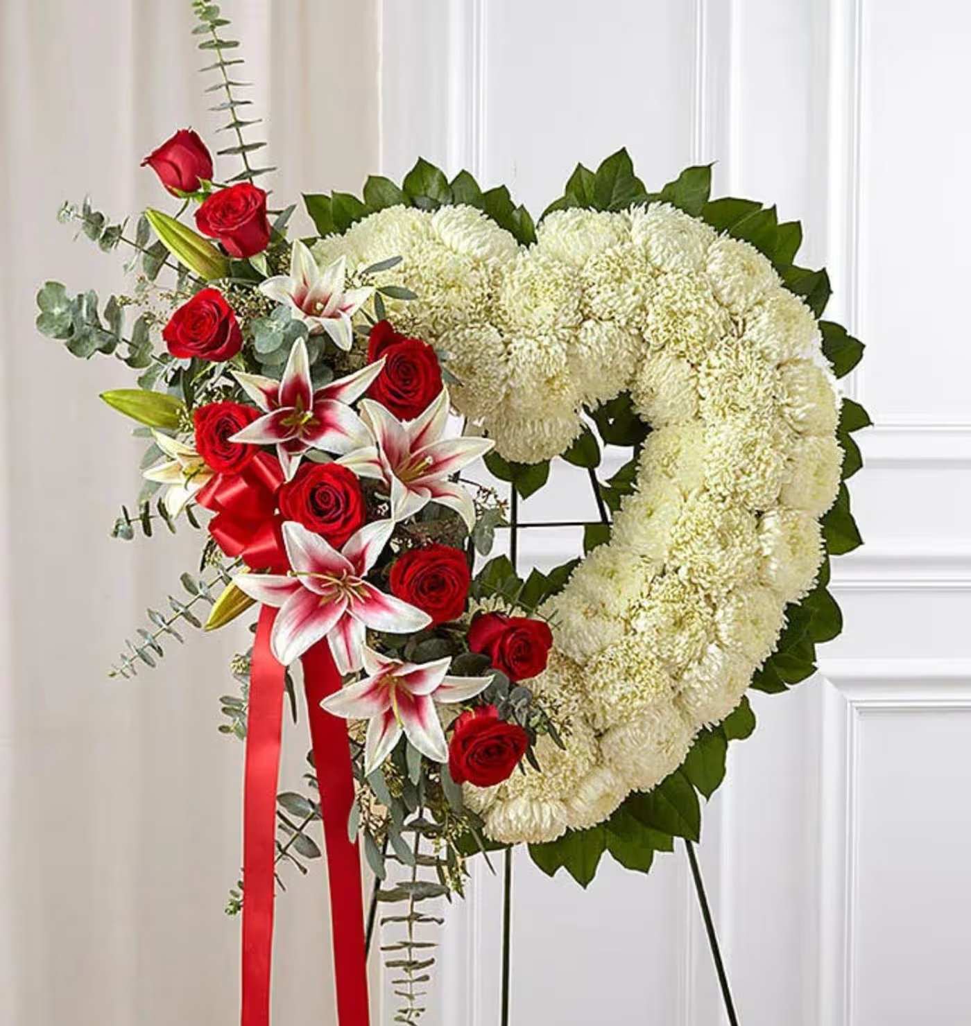 Heart-shaped floral wreath with red roses, white mums, and lilies