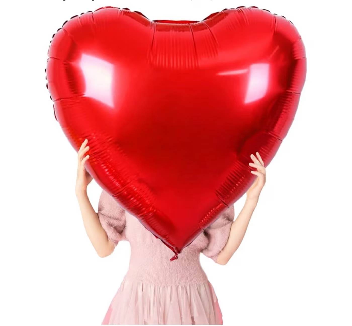 Person holding a large red heart-shaped balloon