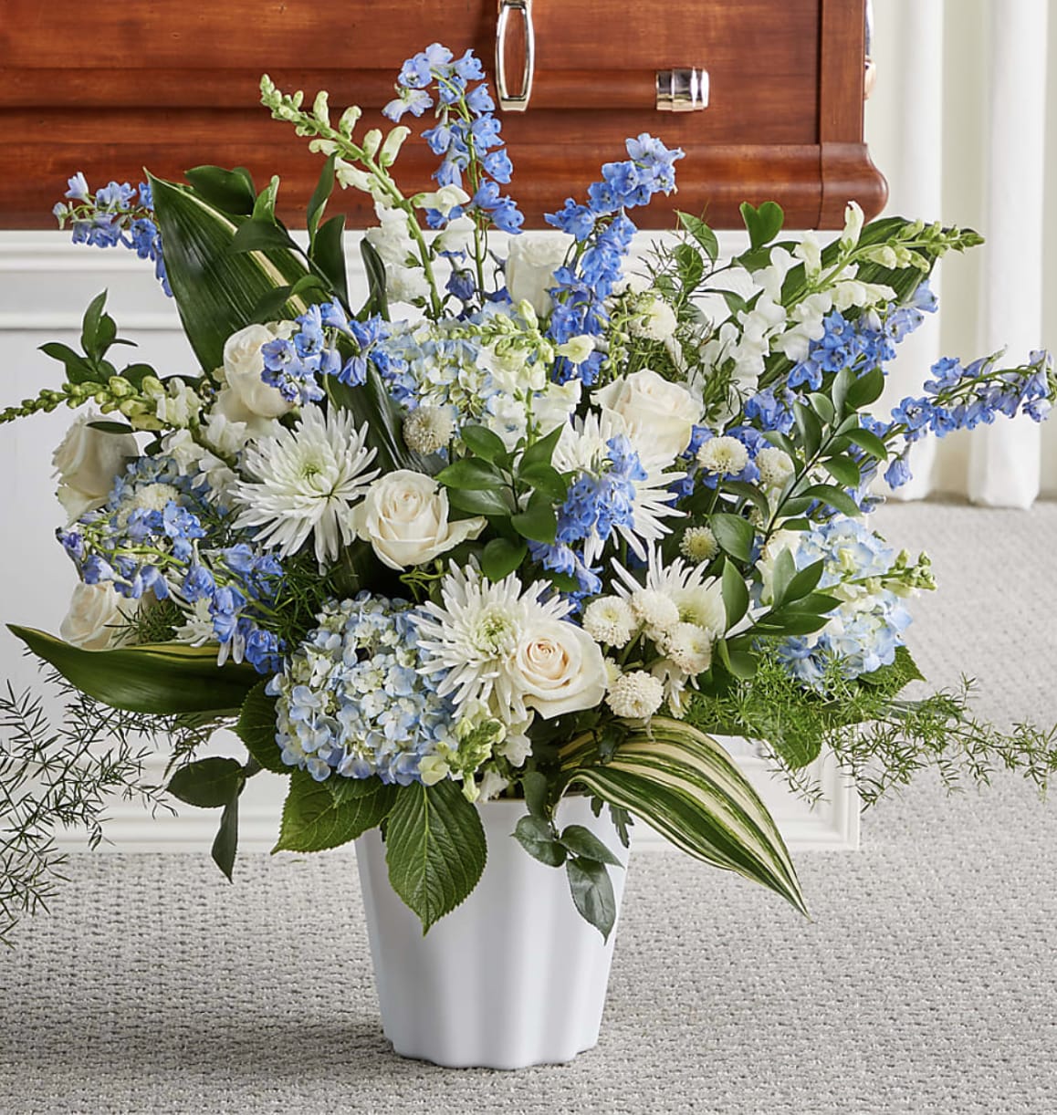 Peaceful Horizons Tribute - Honor a cherished life with the tranquil beauty of Peaceful Horizons Tribute. This elegant arrangement features lush blue hydrangeas, graceful delphinium, pristine white roses, chrysanthemums, and premium seasonal blooms, symbolizing peace, hope, and everlasting love. Handcrafted by the floral designers at Bloom Luxury Box, each tribute is thoughtfully arranged to provide comfort to family and friends while celebrating a life filled with cherished memories. Designed with timeless elegance, it serves as a beautiful expression of sympathy and remembrance.