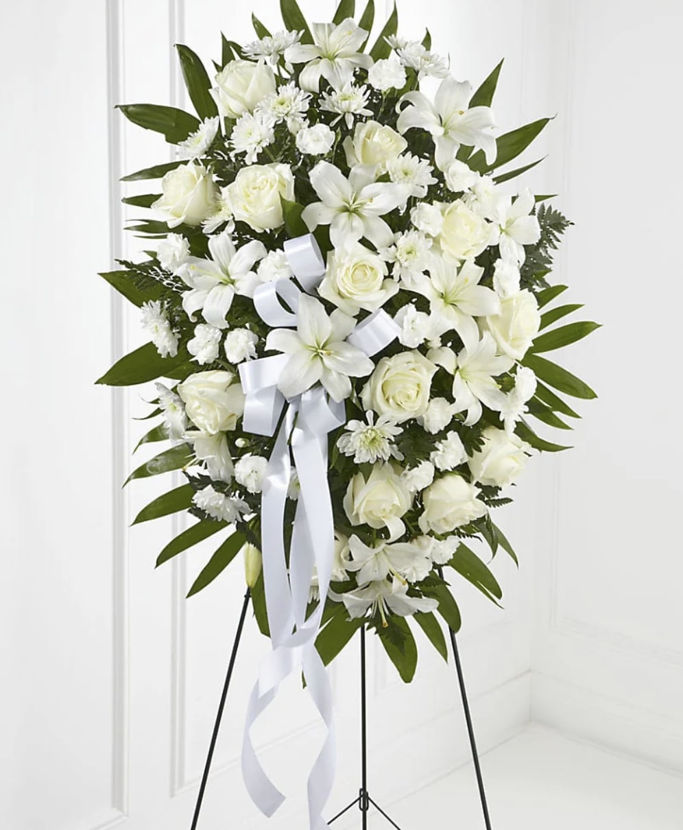 Eternal Peace Standing Spray - Offer a timeless expression of love and remembrance with Eternal Peace Standing Spray. Featuring pristine white lilies, elegant roses, delicate carnations, and classic chrysanthemums, this graceful standing tribute symbolizes purity, hope, and everlasting peace. Handcrafted by the floral designers at Bloom Luxury Box, each arrangement is thoughtfully designed to provide comfort and honor a life remembered with love. Displayed on an easel, this classic sympathy tribute serves as a beautiful expression of respect, compassion, and enduring remembrance.