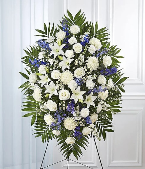 Standing floral spray of white and blue flowers on an easel