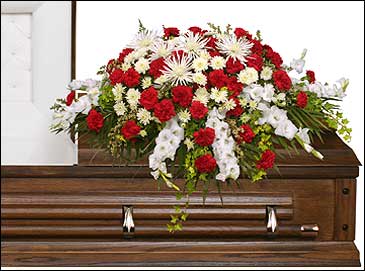 Red and white funeral spray on a wooden casket