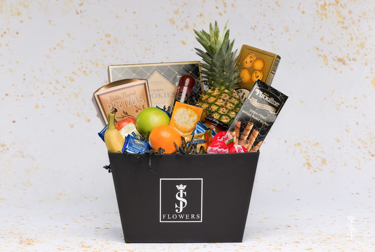 Gift basket with fruit, snacks, and chocolates in a black box