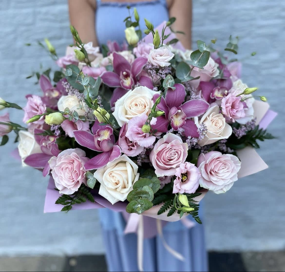 Bouquet of pink and white roses with purple orchids
