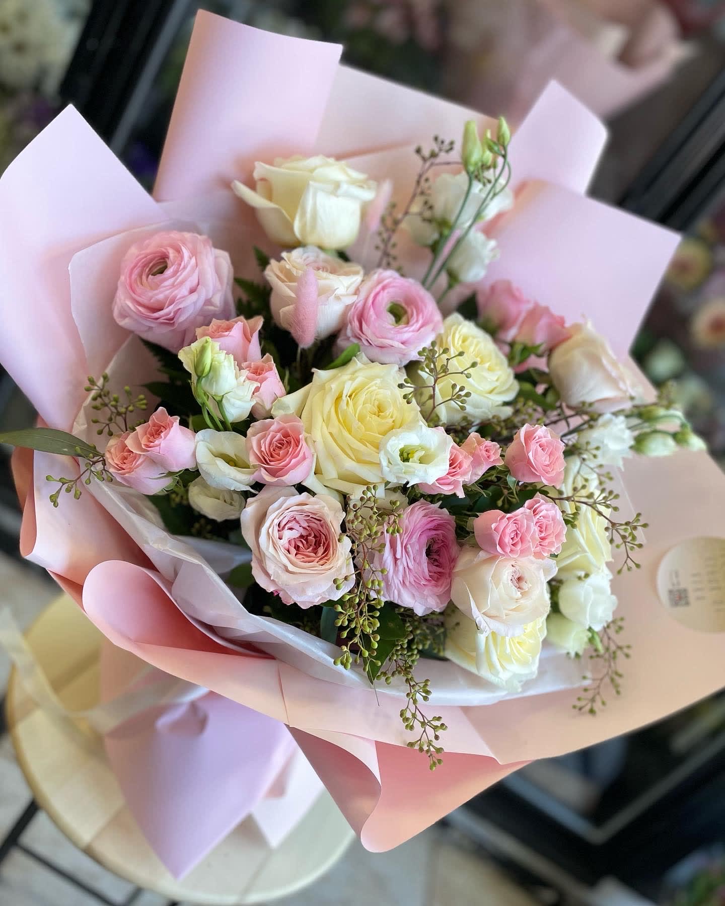Pink and cream rose bouquet wrapped in pastel paper