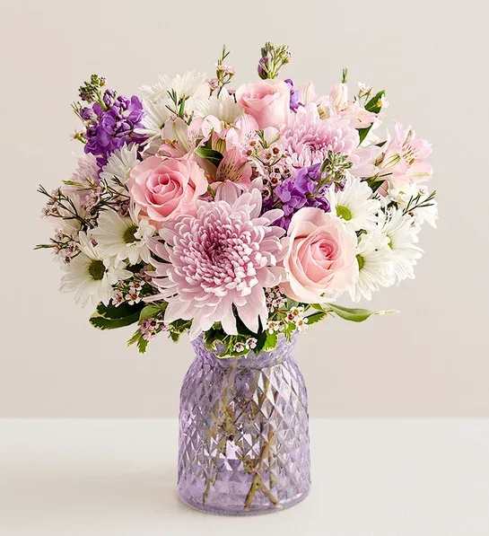 Pink and white mixed bouquet in a purple glass vase