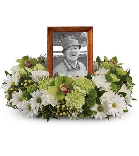 Framed black-and-white portrait surrounded by white and green flowers