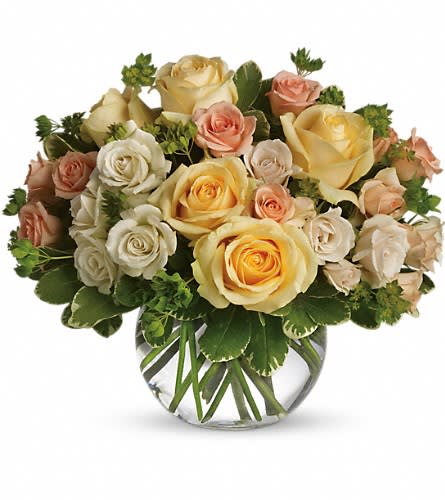 Bouquet of cream, peach, and yellow roses in a clear glass vase