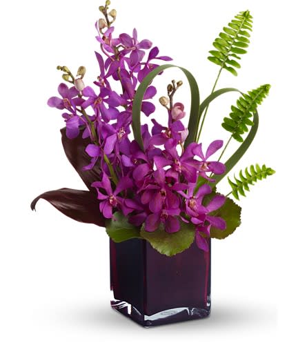 Purple orchid arrangement in a dark square vase