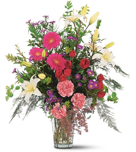 Tall mixed bouquet with lilies, gerbera daisies, roses, and carnations in a glass vase