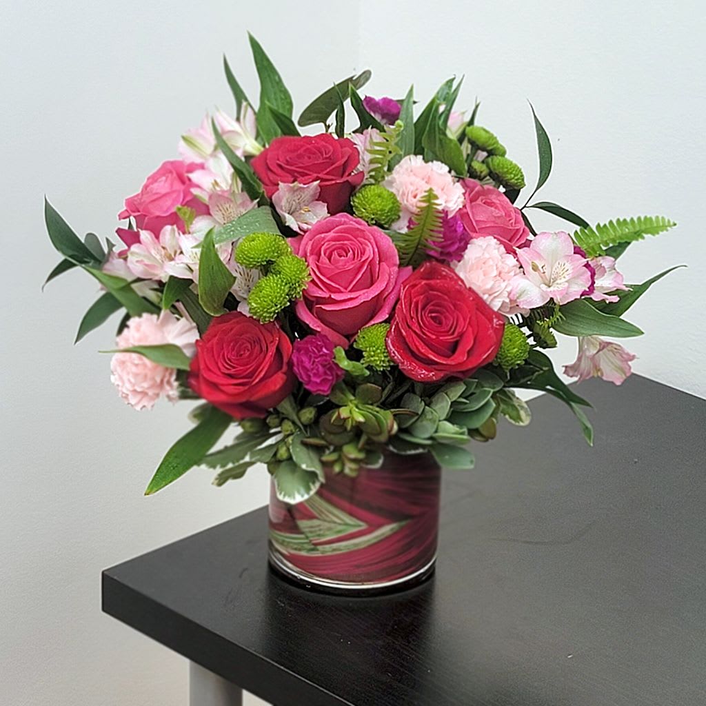 Ruby Floral Bouquet - Featuring a vibrant mix of roses, carnations, and other seasonal blooms, this arrangement is a stunning centerpiece that will brighten any room.   Perfect for birthdays, anniversaries, or simply to show you care.  Approximate Size 12" W x 12.5" H. Celebrate life's special moments and order your bouquet today!