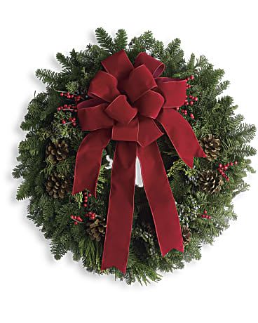 Christmas wreath with a red bow, pinecones, and red berries