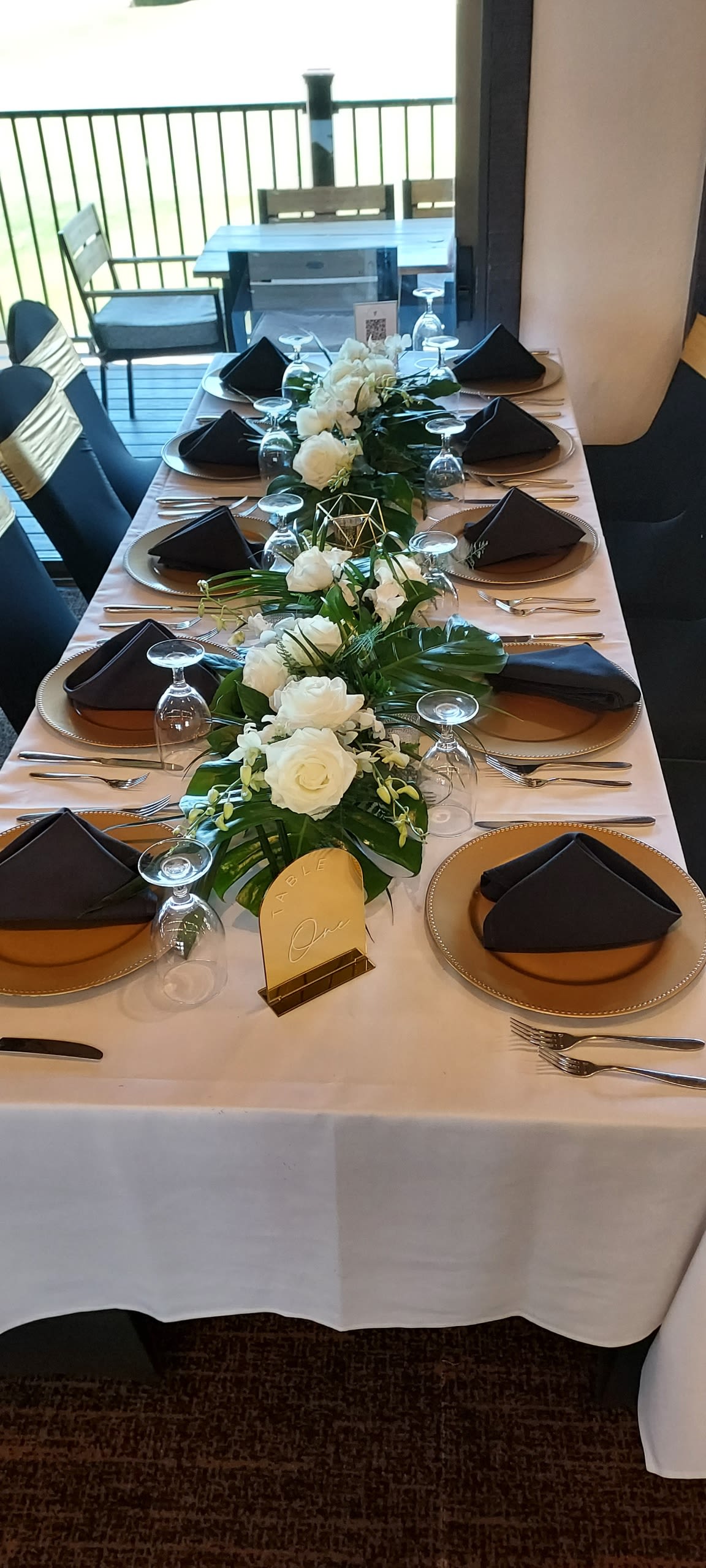 Tropical Table Centerpieces - White and green wedding arrangement with dendrobium orchids and roses, a fresh tropical centerpiece that brings elegant island charm to your ceremony.
