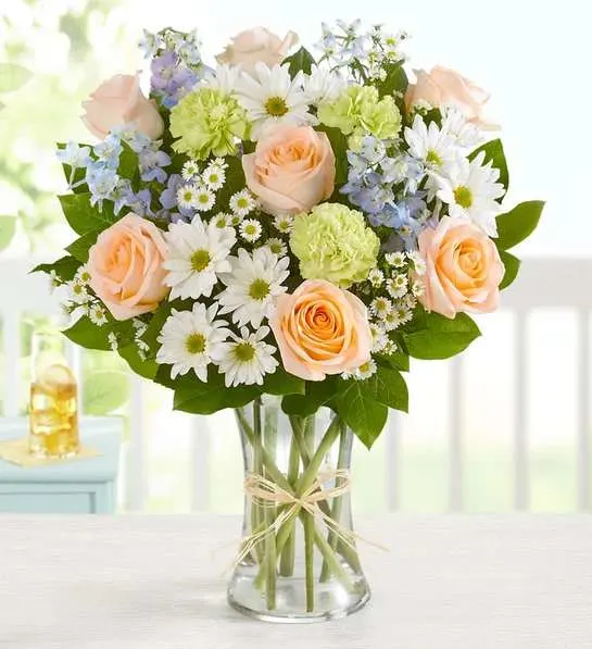 Summer Dunes - Our beach-inspired bouquet captures the blissful beauty of a seaside retreat. Bunches of blooms in cool, soothing shades are arranged in a glass vase tied with raffia for an extra touch of coastal style. It’s a gift that celebrates the carefree spirit of summer, while surprising the people you care about most.