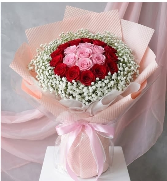 A charming Rose wrapped Bouque - A charming and elegant bouquet featuring 24 beautiful pink &amp; red roses gracefully accented with fresh Baby Breath fillers and wrapped in stylish pink wrapping paper. This lovely arrangement radiates warmth, admiration, and gentle affection — making it a perfect gift for birthdays, celebrations, or simply brightening someone’s day.