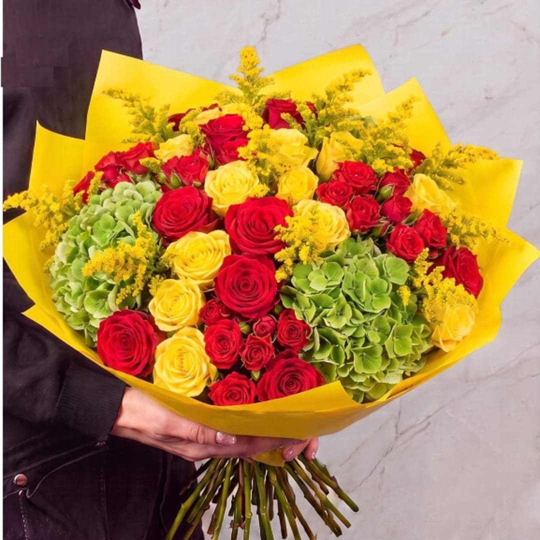 Bouquet of red and yellow roses with green hydrangeas wrapped in yellow paper