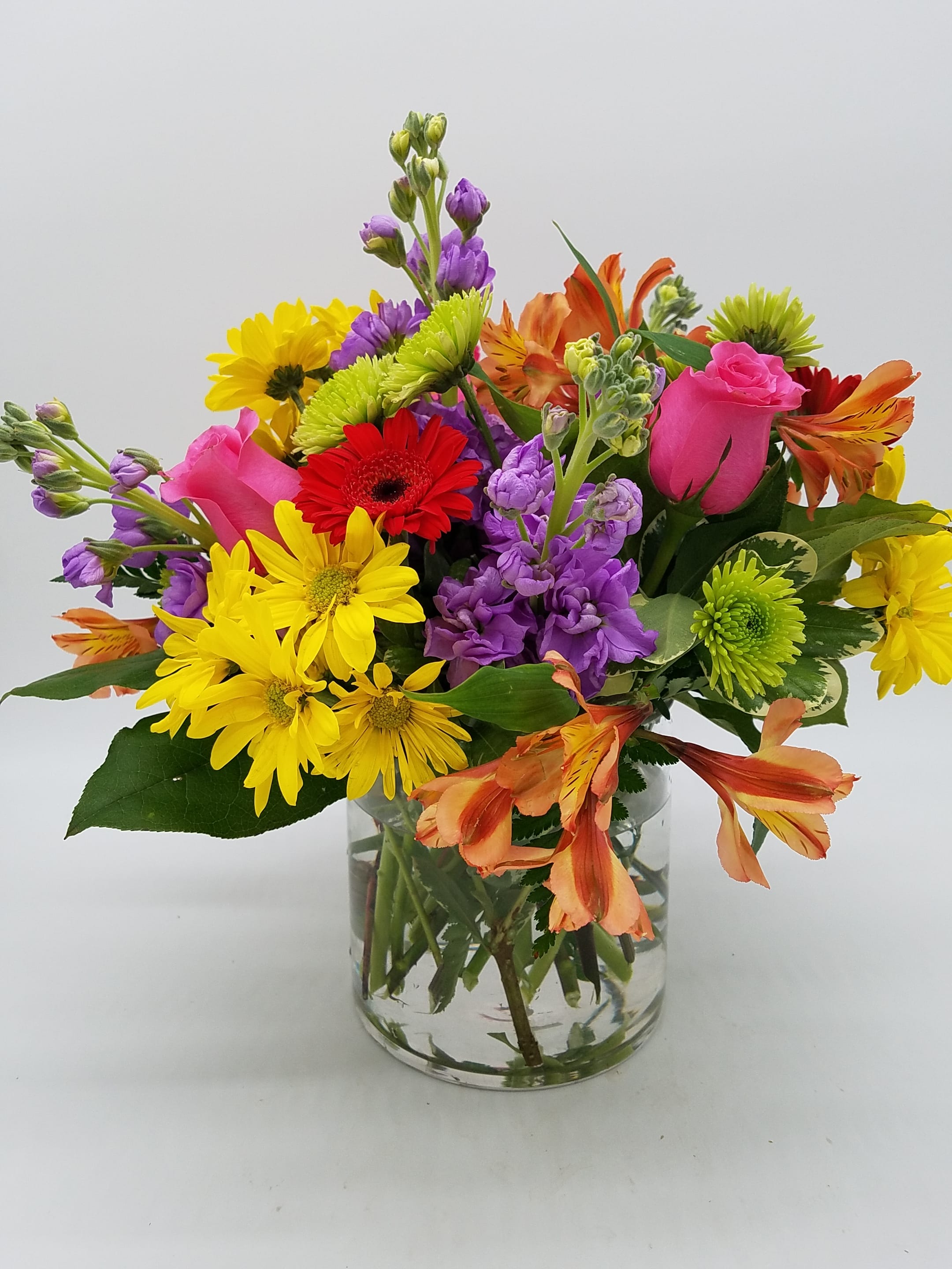 Mixed bouquet of colorful flowers in a clear glass vase