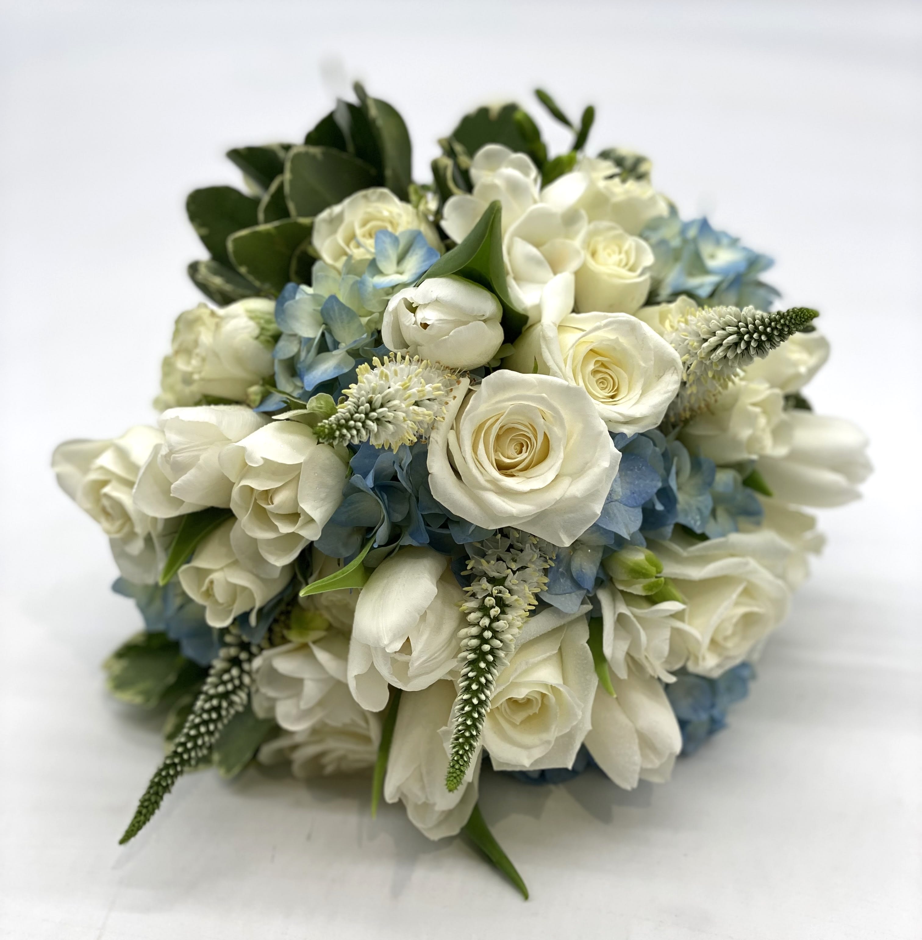 Beauty in Blue Clutch Bouquet - A lush mix of white flowers designed within a blue hydrangea. 