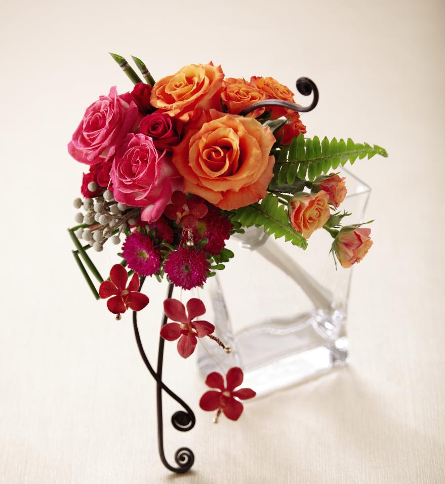 FTD Brilliant Blossoms Bouquet - The FTDÂ® Brilliant Blossomsâ¢ Bouquet is a bright and beautiful way to   capture their attention. Fuchsia roses, spray roses, and matsumoto   asters are brought together with orange roses and spray roses, red   mokara orchids, silver brunia and a variety of lush greens, accented   with gold pixie pearl pins at the base of the stems and presented in a   silver metallic twist bouquet holder for the finishing touch. Approx.   12âH x 8âW. 